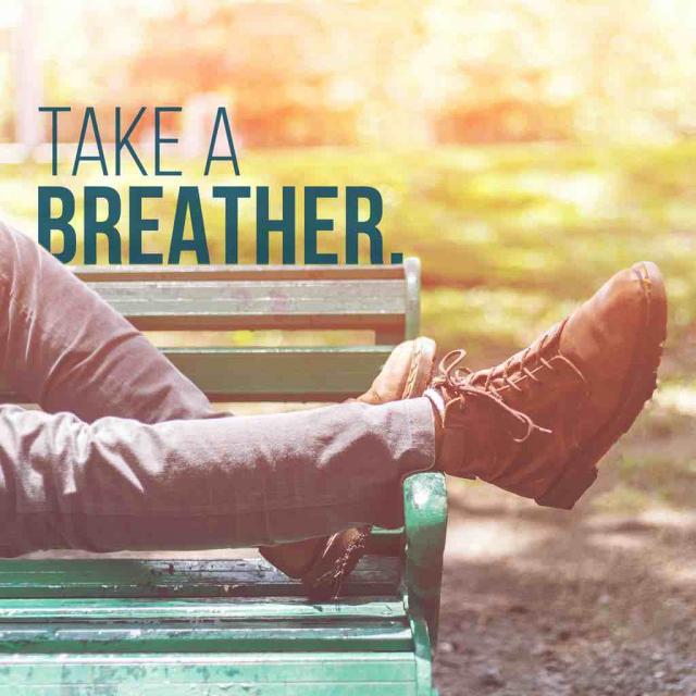 Feet and legs of someone lying on a bench with text saying "take a breather"