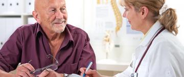 Doctor discussing information with elderly, male patient